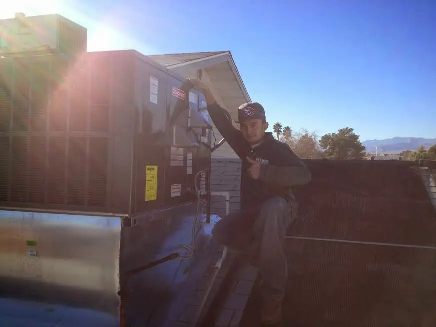 HVAC technician performing Boiler Repair on a rooftop unit in Ypsilanti
